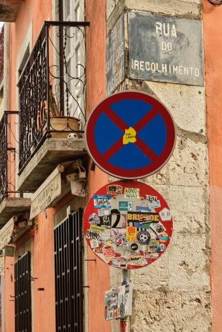 Quaint Lisbon street signs covered in stickers, capturing vibrant urban life.